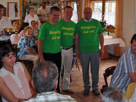 Gartenfrühstück im Kleingartenverein Weiße Schanze: Grünes Überraschungsgeschenk: T-Shirt mit dem Aufdruck: Kleingärten sind cool.<br>
Ratsherr Stefan Brix, JSW, Hans-Joachim Christoph, Vorsitzender des KGV